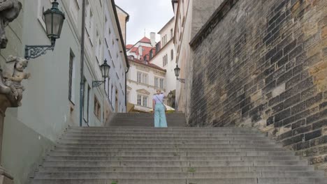 woman descending stairs surrounded by buildings in narrow alleyway