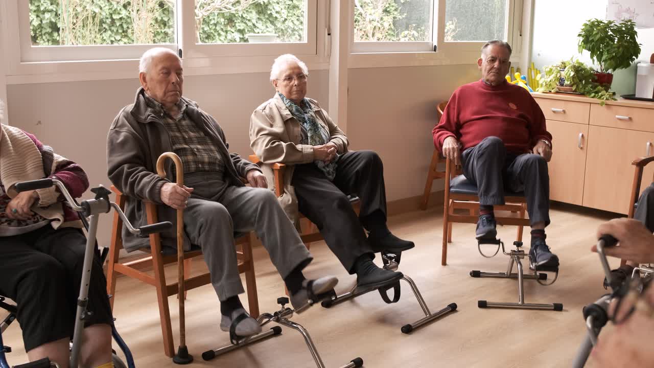 Senior people exercising with bike pedals in retirement home
