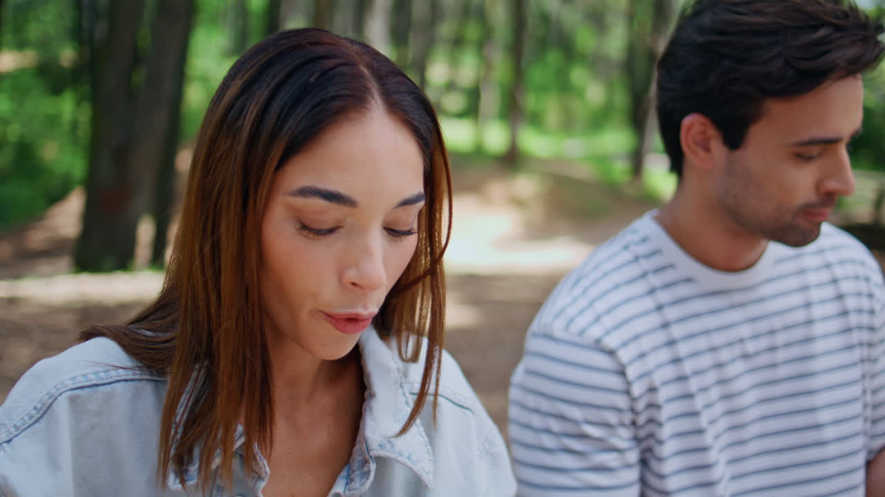 Cheerful couple enjoying picnic in sunny park closeup. Smiling man and woman