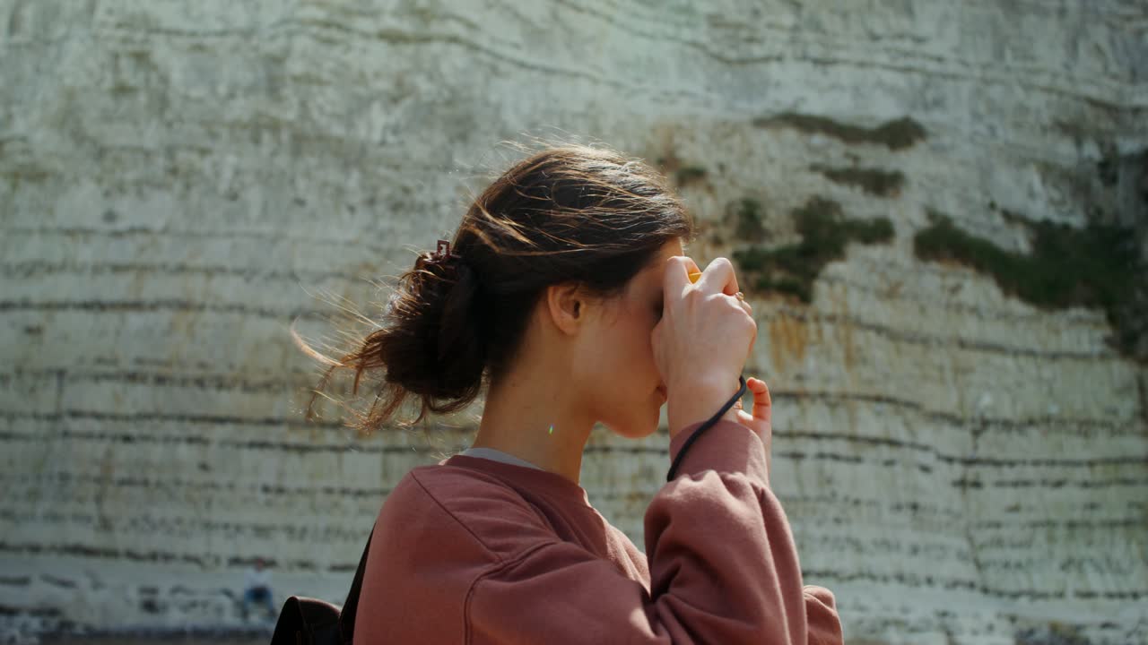 Donna che scatta una foto a una scogliera