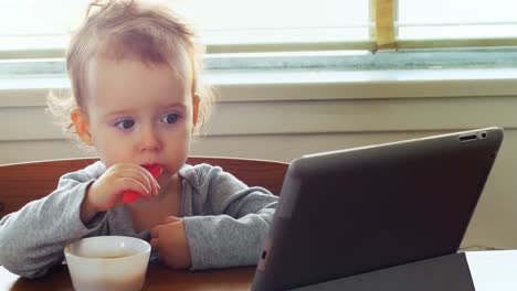 baby using digital tablet while having breakfast 4k