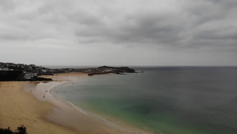 disparo de drones aéreos en aumento mirando por encima de la playa de porthminster a st ives, cornualles, inglaterra, reino unido