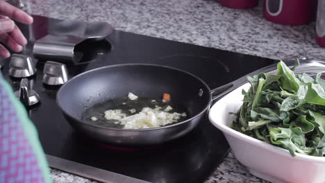 Mujer-Haciendo-Espinacas-Salteadas-En-La-Estufa