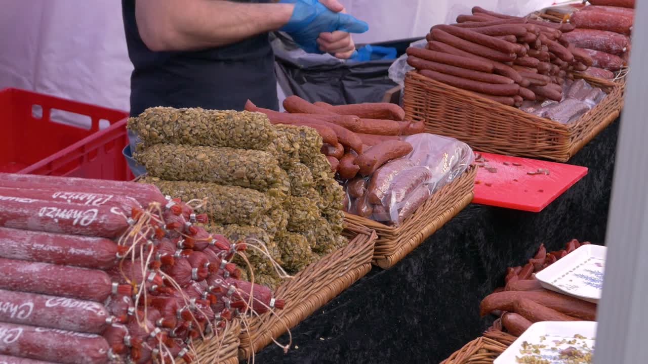 salchichas españolas, italianas y alemanas en un puesto de mercado filmado en un festival gastronómico en inglaterra