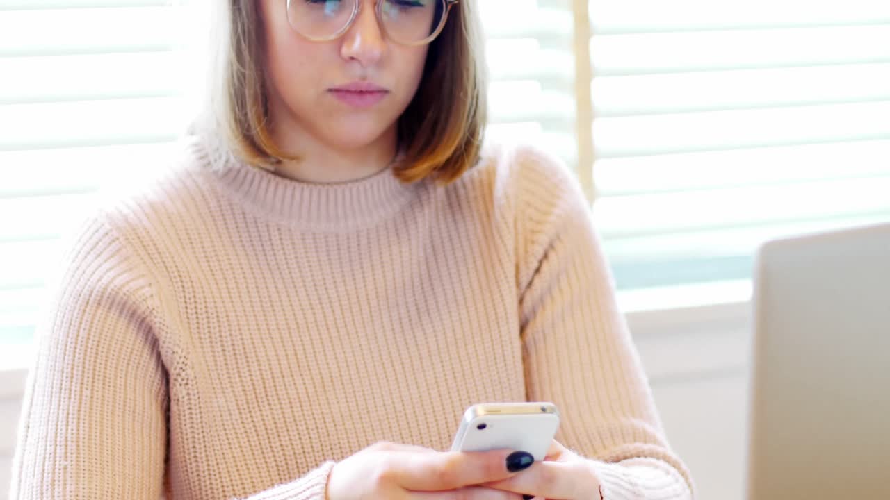 아름다운 여성이 휴대전화로 문자 메시지를 보내고 있습니다.