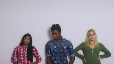 3 young people leaning on wall copy space