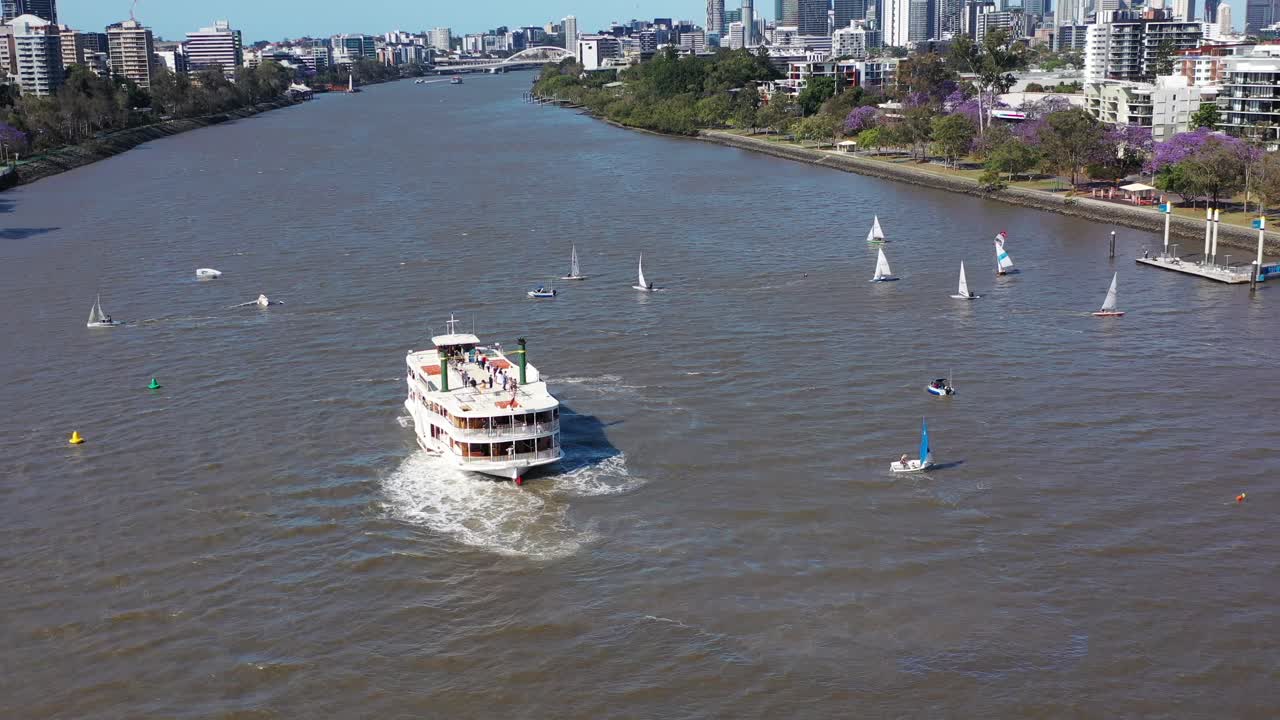 disparo de avión no tripulado volando hacia atrás revelando muchos pequeños barcos que tienen una carrera de vela en el río brisbane, cerca de west end y toowong