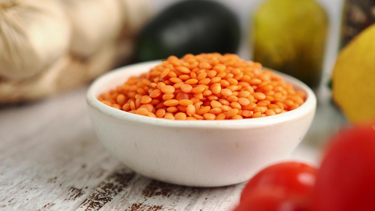 Bol de lentilles corail crues sur un comptoir de cuisine