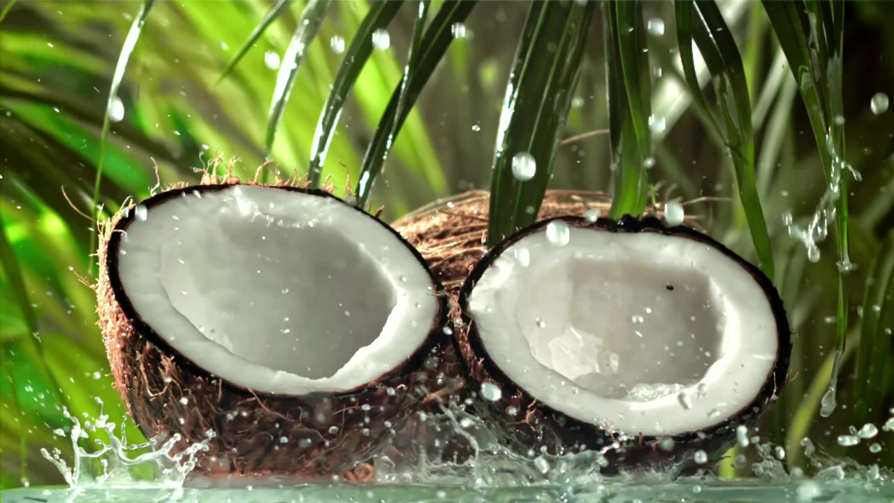 Noci di cocco fresche con schizzi d'acqua al rallentatore