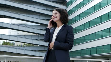 content businesswoman talking by smartphone