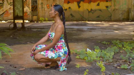 Epic-view-of-sexy-model-in-a-long-dress-stopping-at-an-abandoned-warehouse-with-grafitti-art-in-the-background