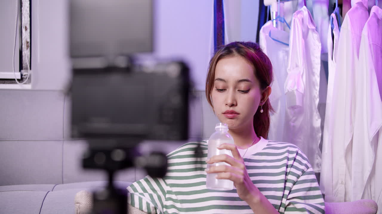 un vlogger toma un sorbo refrescante de agua mientras se involucra con los espectadores durante una transmisión en vivo.