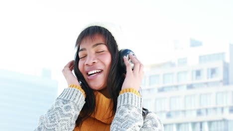 Woman-listening-to-music-on-a-winters-day