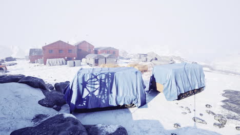 snow covered research station with covered equipment in harsh winter conditions