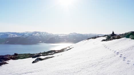 montañas nevadas con luz solar brillante reflejada en el fiordo de blaheia, noruega