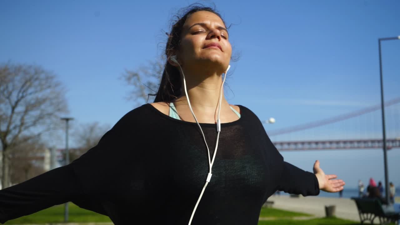 chica deportiva relajada con los ojos cerrados entrenando en el parque