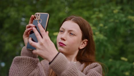 teenage girl taking a selfie outdoors