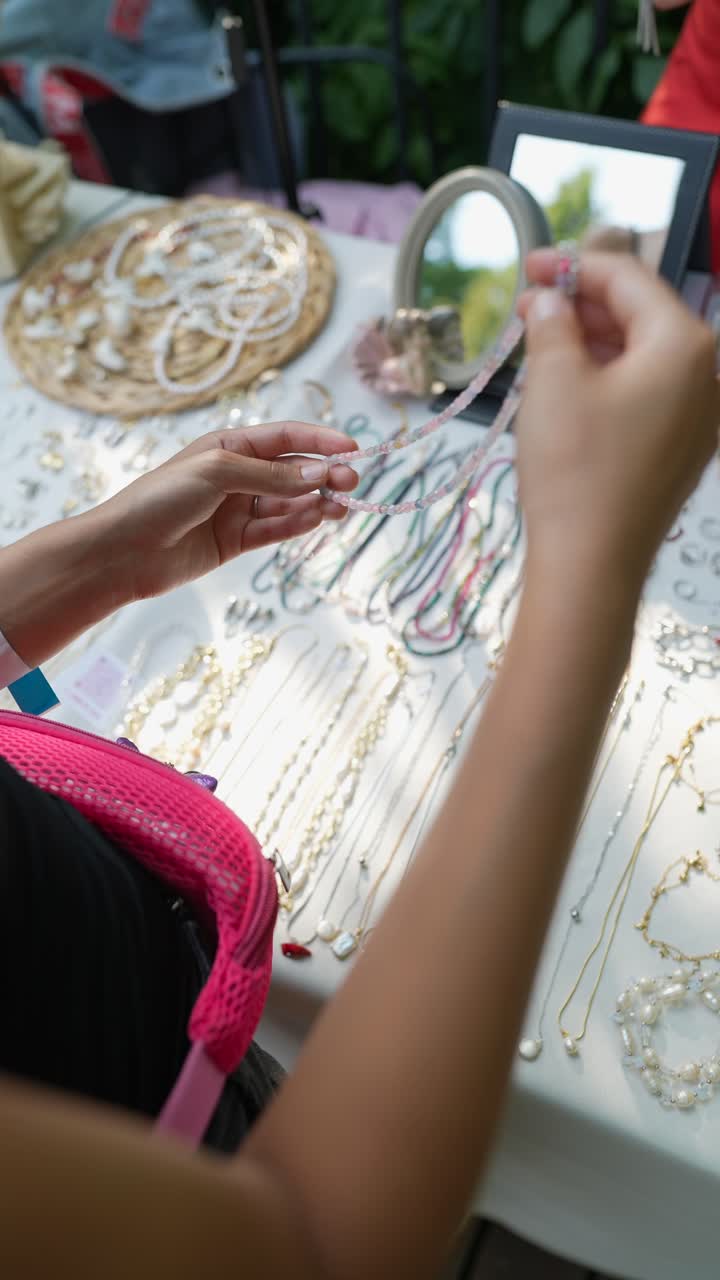 mujer mirando collares de cuentas en el mercado al aire libre