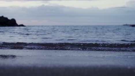 waves crashing on a beach at dusk