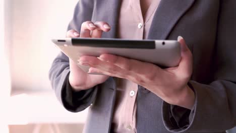 mujer de negocios escribiendo en su tableta