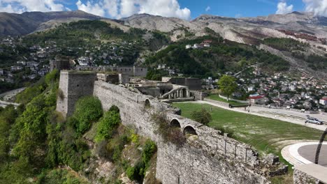 stone fortress on a hill in gjirokastër, albania, with mountains and town below