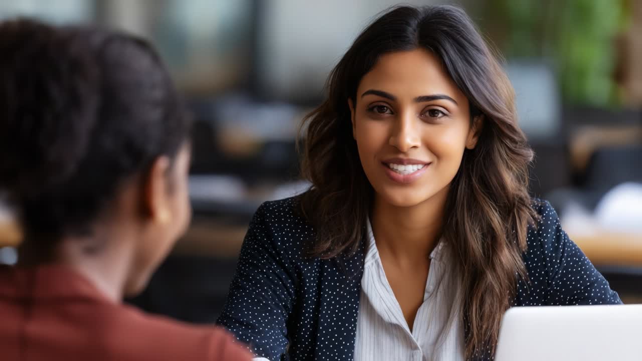 A professional woman engages in a friendly conversation with another ...