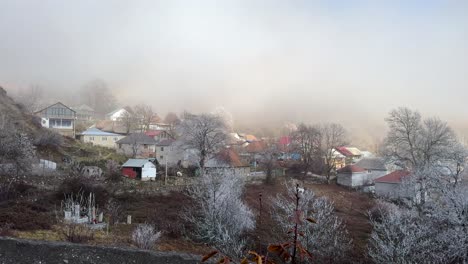 frost-covered trees and rooftops in a quiet foggy morning in durja village. durja, azerbaijan