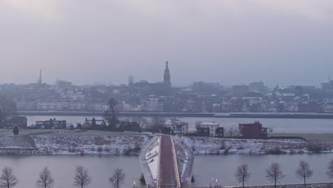 dron porusza się w kierunku kościoła stevena w mieście nijmegen, podczas gdy statek przekracza waal.