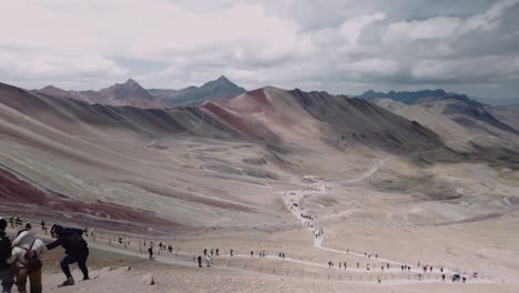 tourists at the vinicunca, rainbow mountain in peru. - handheld shot
