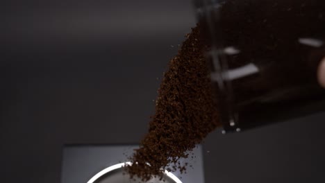 pour out coffee grinder mug into a coffee machine in super slow motion