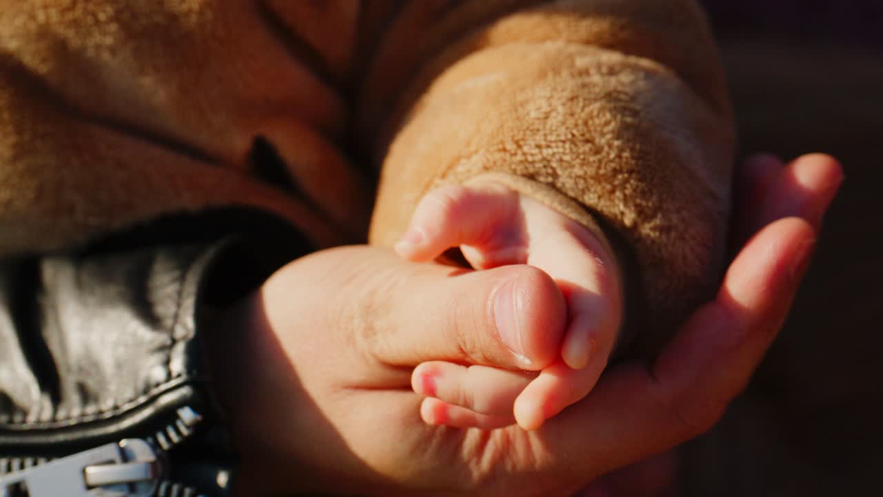 A Tender Moment: The Intergenerational Connection Between an Adult and a Child, Highlighted by Their Hands Holding Each Other in a Loving Embrace