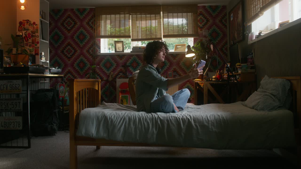 편안한 침실에서 스마트폰을 사용하는 젊은이