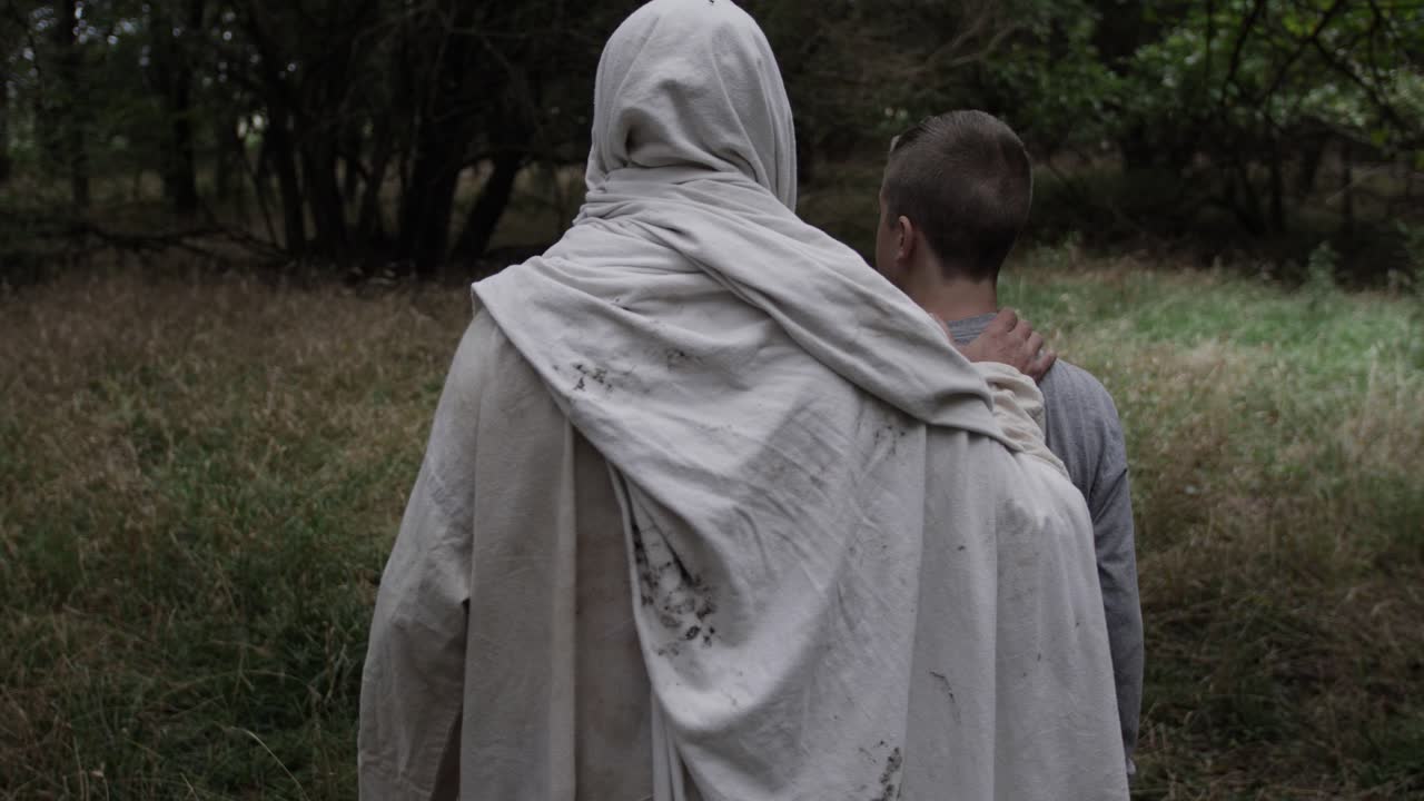 예수는 슬로우 모션으로 어린 십대 소년을 이끌고 숲을 걷는다