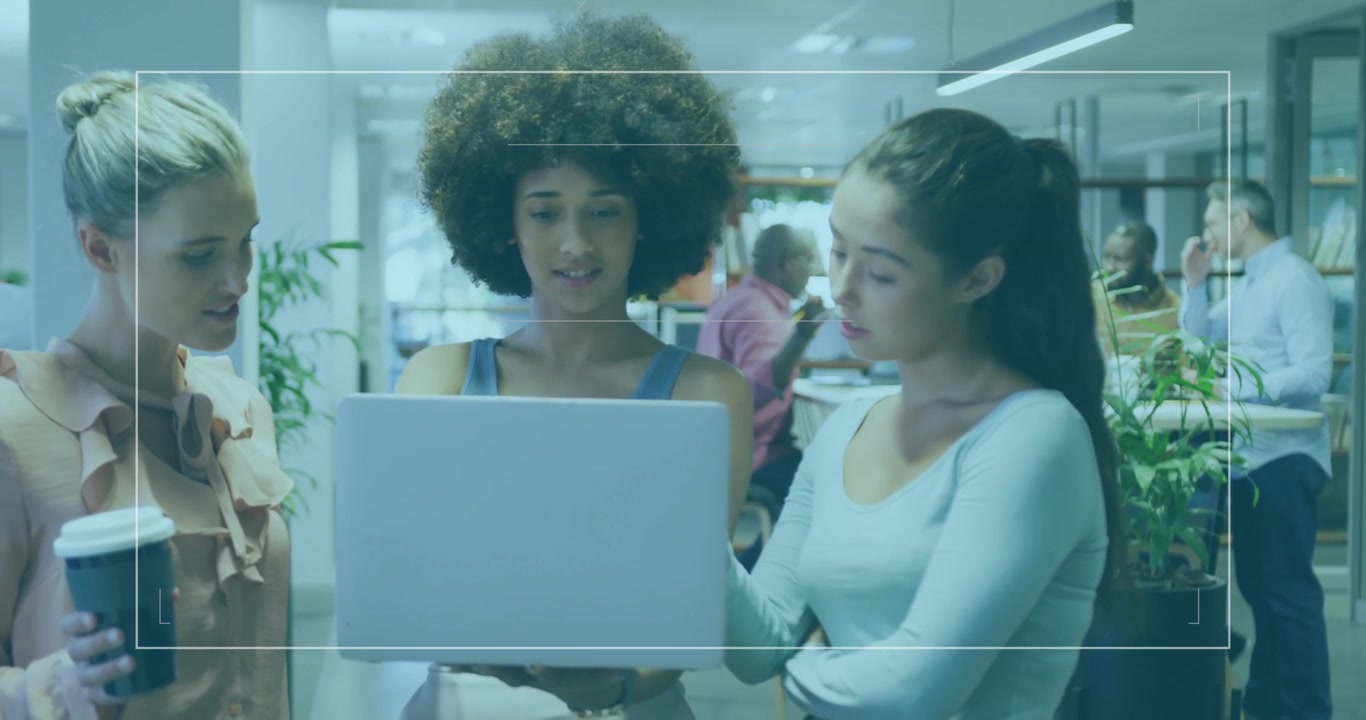 Three colleagues holding laptop high and analyzing data with translucent overlay and moving charts