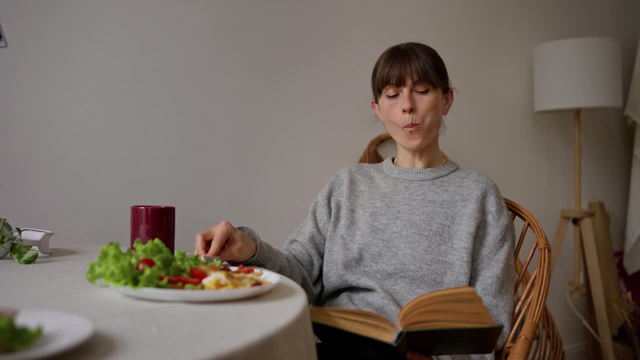 Woman Eating Breakfast and Reading a Book at Home