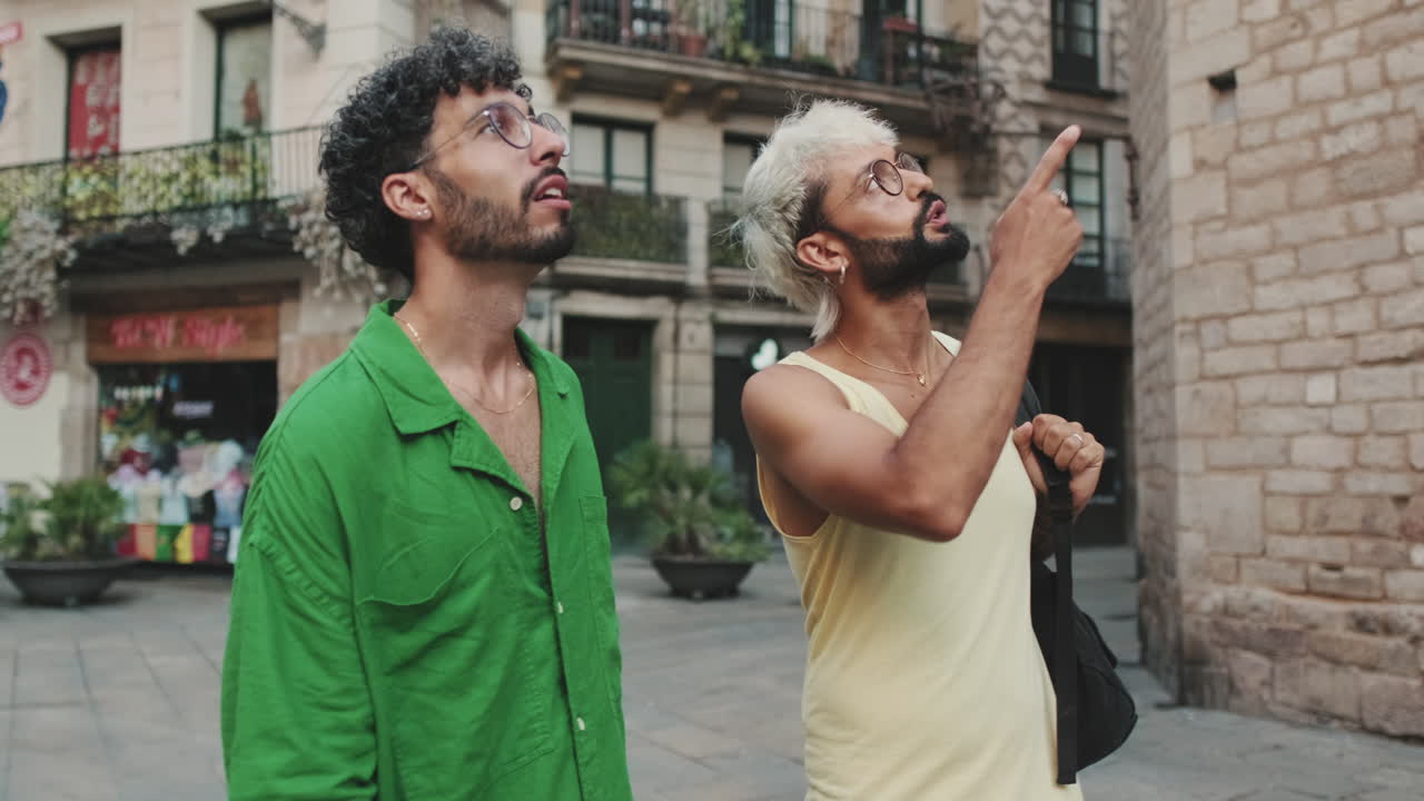 Two Young Men Sightseeing in a City, Pointing at Architecture