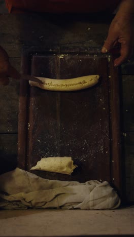una toma vertical de una mujer preparando chipa, una comida tradicional paraguaya, para más tarde llevarla al tatakua, un horno de arcilla tradicional paraguayo, típicamente hecho durante la semana santa