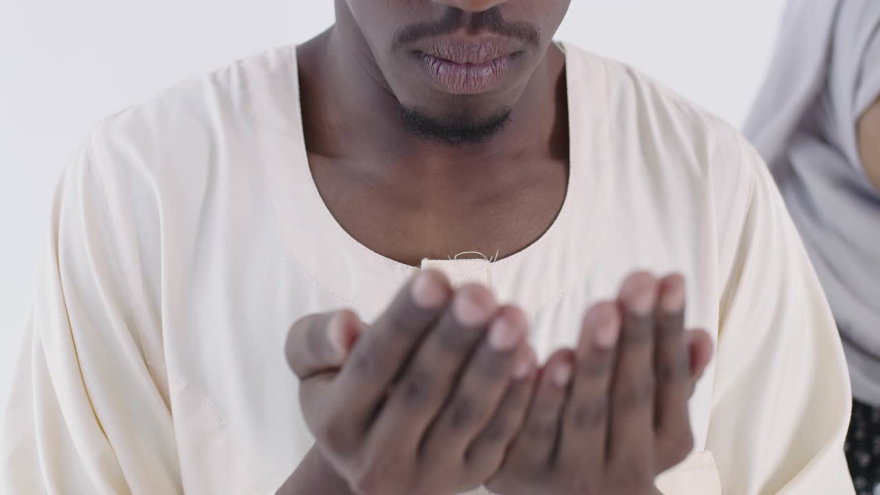 una pareja musulmana negra africana en su casa en ramadán haciendo la tradicional oración de fatiha a alá dios mientras llevan ropa de moda tradicional sudanesa en el estudio