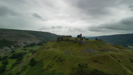 ancient castle ruins on a green hill under a cloudy sky