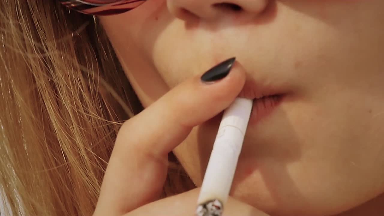 mujer fumando un cigarrillo de cerca