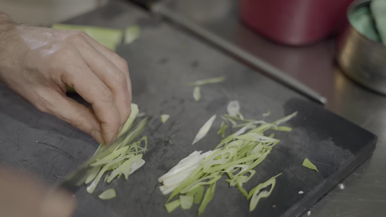 el chef cortando cebollas verdes