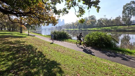 people cycling and running along river path