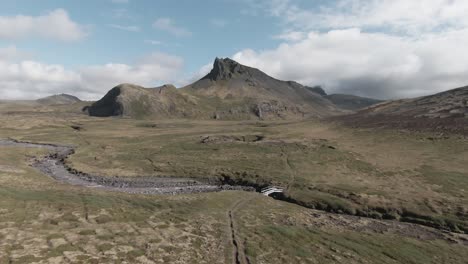 peaceful scenery of countryside: mountains, river and small bridge, iceland