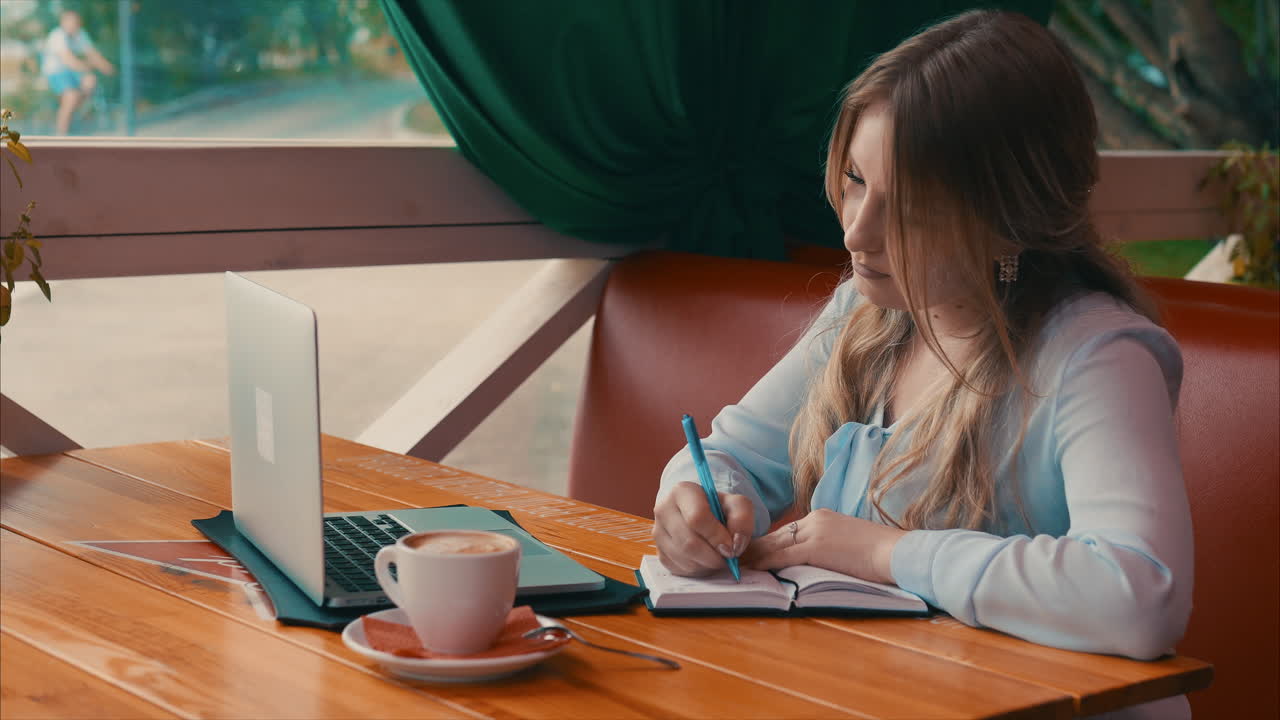 야외 카페 에서 노트북 을 사용 하는 여자