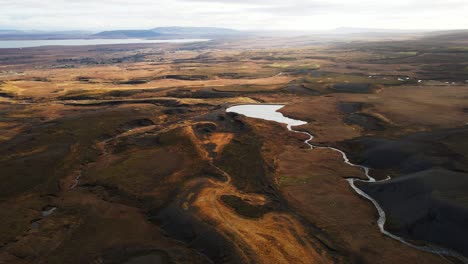 beautiful aerial of pristine icelandic landscape with a small river flowing into a pond