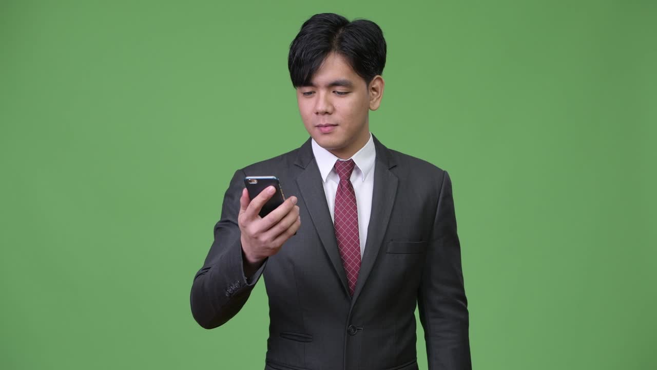 휴대전화를 사용하는 젊은 잘생긴 아시아 사업가
