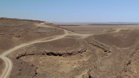 Dirt-road-over-Gara-Medouar-mountain-at-Errachidia-near-Sijilmasa-in-Morocco,-Africa