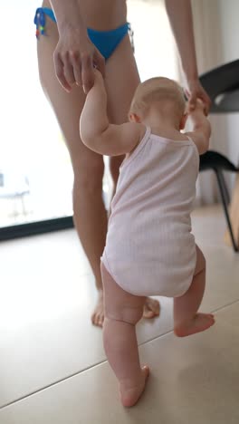 mother helping baby to walk