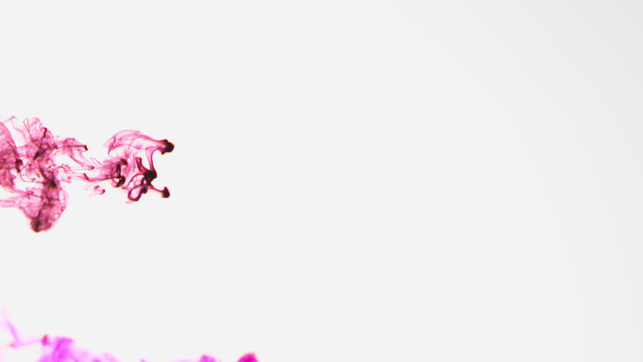 빨간색과 분홍색 페인트 또는 염료가 색 배경에 물에 떨어지면서 회전하는 다채로운 연기 배경을 만니다.