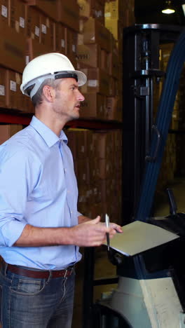 warehouse manager working with foreman in forklift